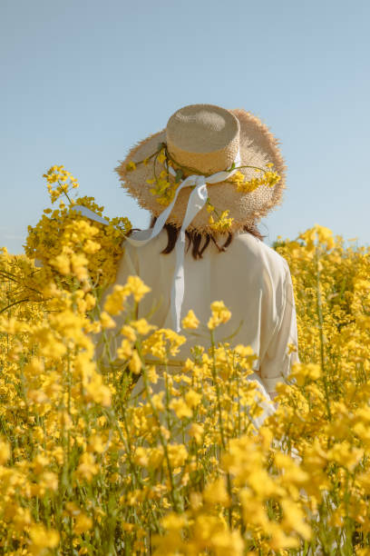 istock woman standing in rapeseed field rear view from behind 1341853082