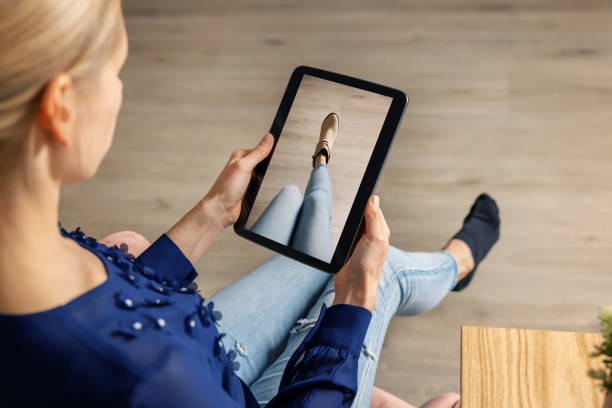 виртуальная примерка - женщина примеряет обувь онлайн с помощью цифрового планшета - киберпространство стоковые фото и изображения