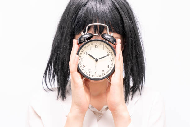 Business woman holding alarm clock. Trouble with deadline, concept