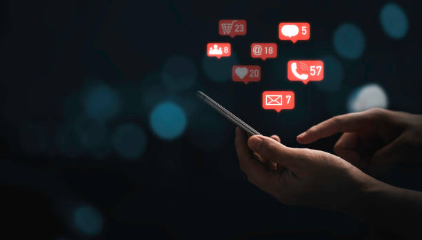 istock Hand using smartphone to send message and social media icons with blue bokeh background for marketing information concept. 1341854084