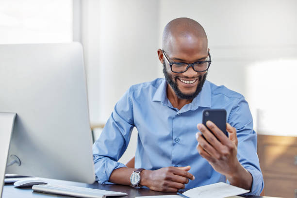 istock Shot of a businessman using his cellphone while sitting at his desk 1341854837