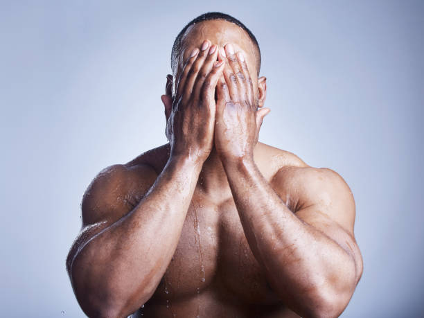 istock Studio shot of a handsome young man washing his face against a grey background 1341856592