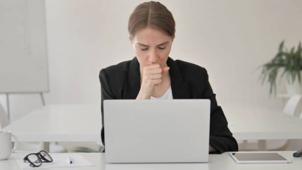 istock Sick Young Businesswoman Coughing at Work 1341859879