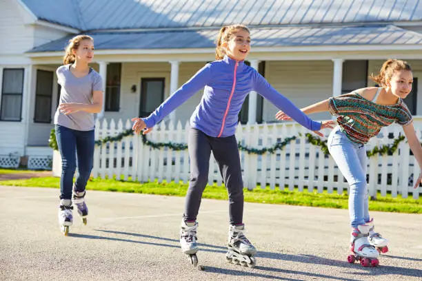 Photo of Teen girls group rolling skate in the street