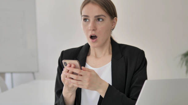 istock Shocked Young Businesswoman Using Smartphone 1341860948