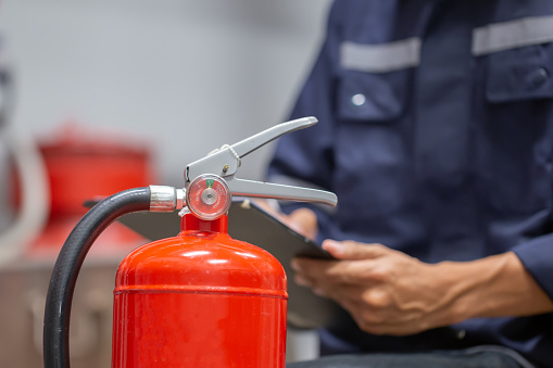 Engineer are checking and inspection a fire extinguishers tank in the fire control room for safety training and fire prevention.