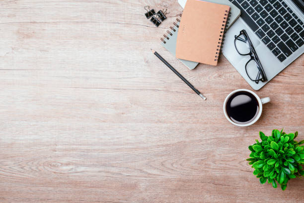 istock Work from home. desk office with laptop, blank notepad, coffee cup and pen on wood table. Flat lay top view copy spce. 1341861266