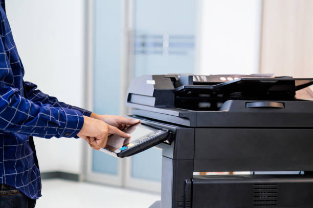 istock Businessmen press button on the panel for using photocopier or printer for printout and scanning document paper at office. 1341861279