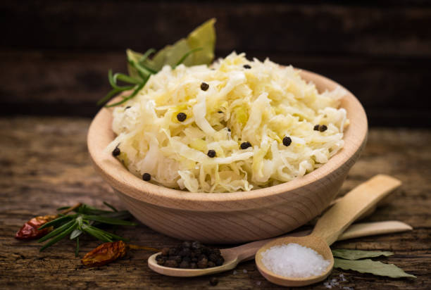 gesundes sauerkraut mit schwarzem pfeffer und gewürzen auf dem holztisch - sauerkraut salad coleslaw cabbage stock-fotos und bilder