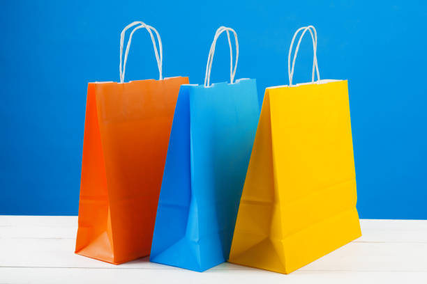 istock Paper shopping bags with copy space on blue background 1341872131