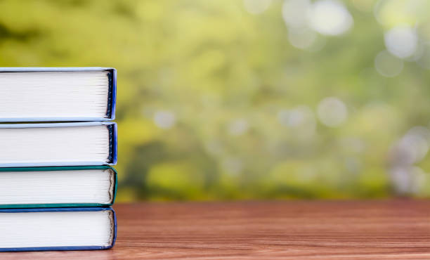 istock A stack of books on a wooden table with place for text. 1341872187