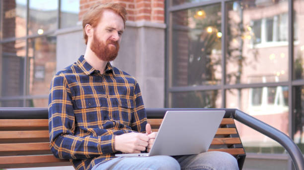 istock Redhead Beard Young Man Frustrated by Results, Sitting Outside Office 1341875900