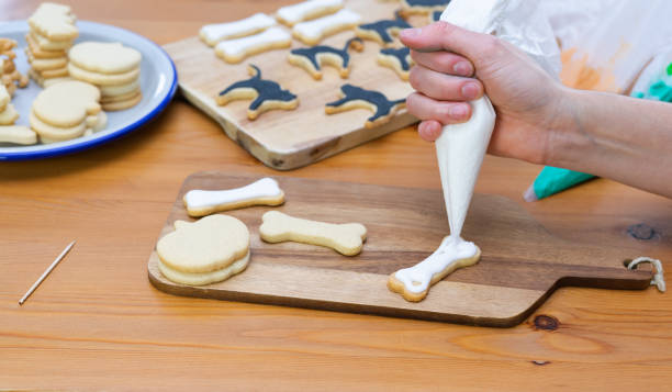 istock Woman's hand decorating cookies for Halloween with piping bag. 1341877288