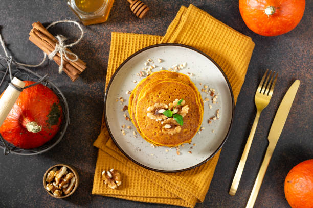 istock Pumpkin pancakes in a ceramic plate on a dark background top view 1341879047