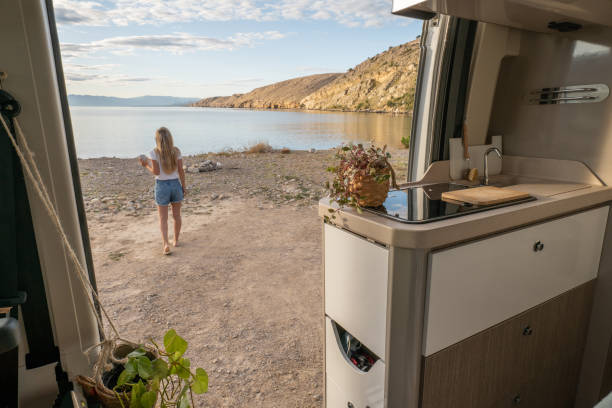 istock Woman free camping on wild beach, van view 1341879893