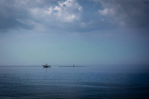 istock A motorboat pulling water skier in the calm, pastel colored sea. 1341880341