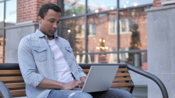 istock African Man working on Laptop, Sitting on Bench 1341881572
