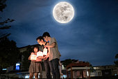 Asian Chinese father with children and nephew holding paper lantern, celebration mid autumn festival.