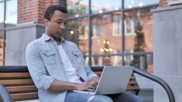 istock African Man Coming and Sitting on Bench to Use Laptop 1341882001