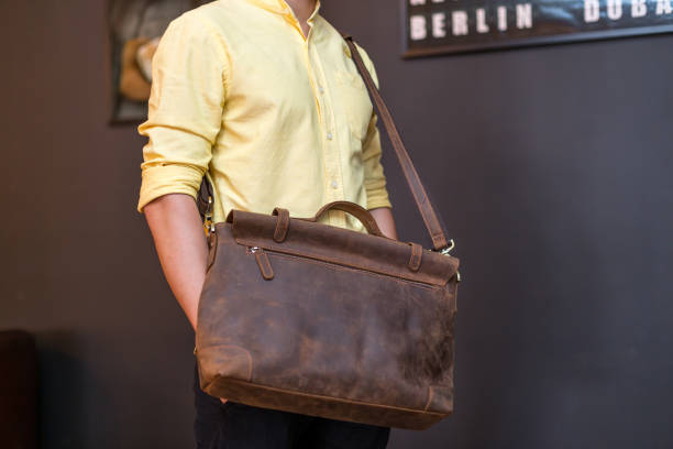 istock Man carries brown leather messenger bag in the hand 1341883050