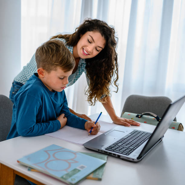 istock Mother helping her son with online schooling 1341883091
