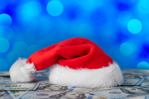 istock Santa hat on heap of US dollars with space for copy 1341885271