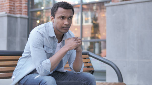istock Stressed African Man with Headache Sitting Outdoor 1341886097