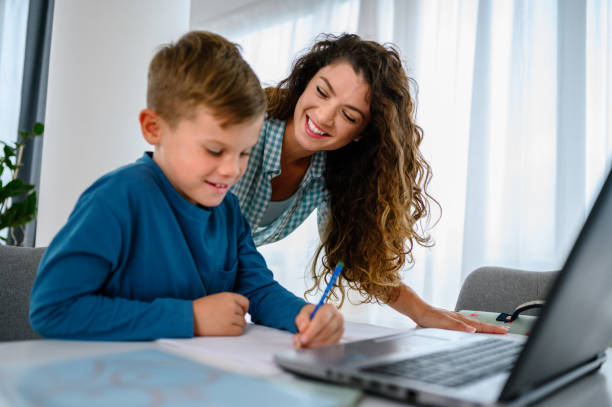 istock Mother helping her son with online schooling 1341887322