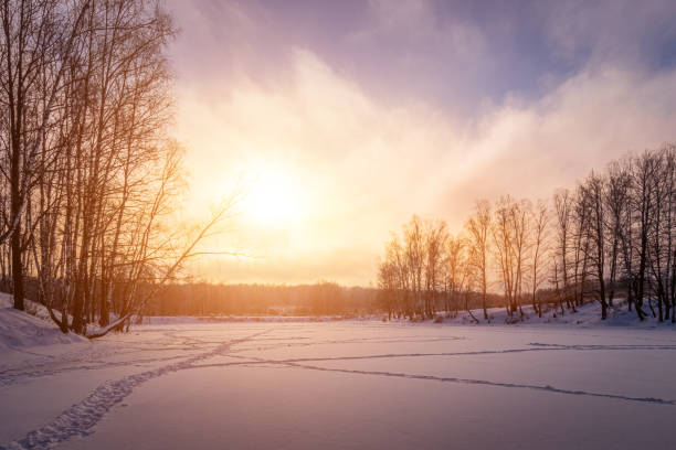 istock Sunset or sunrise on a frozen pond with birch trees 1341888918