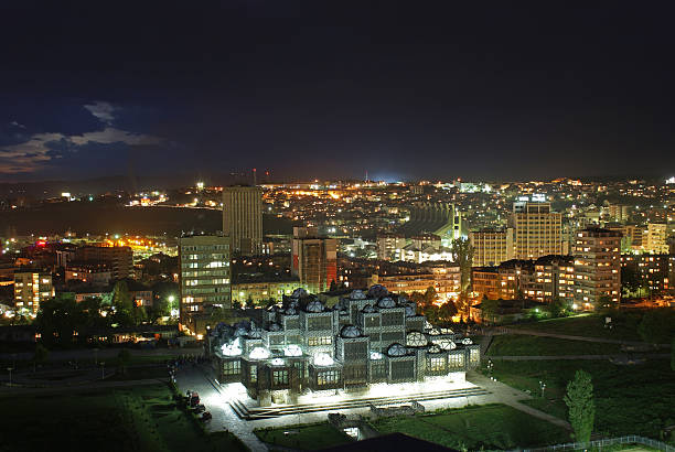 Balkan Nightscape (Prishtina, Kosovo) Prishtina, Kosovo: Kosovo's capital city as seen from above at night. The national library illuminates the foreground. The downtown buildings and a soft evening cloudscape provide a colorful backdrop. pristina stock pictures, royalty-free photos & images