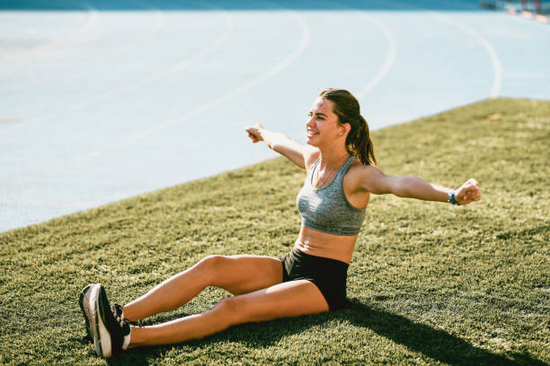 istock Happy Female Athlete Resting After Full Day Training On Grassland 1341890296