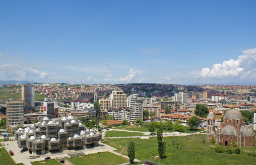 Prishtina, Kosovo: Skyline of the Kosovar capital on a sunny summer day. The National Library and an Othodox church can be seen in the foreground.