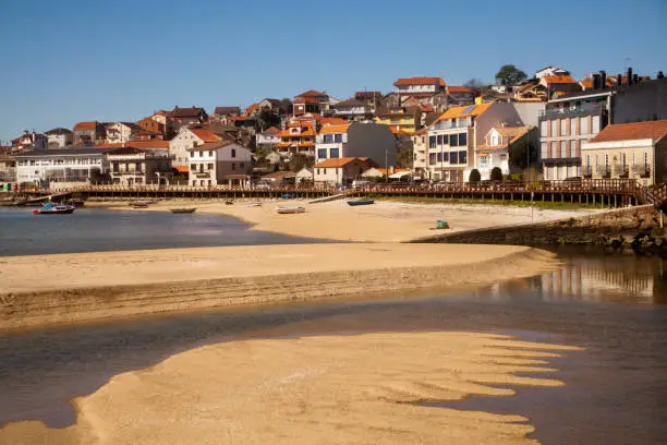 Aldán  beach and village, Cangas do Morrazo, Rías Baixas, Pontevedra province, Galicia, Spain. Village houses by the sand, low tide pools.