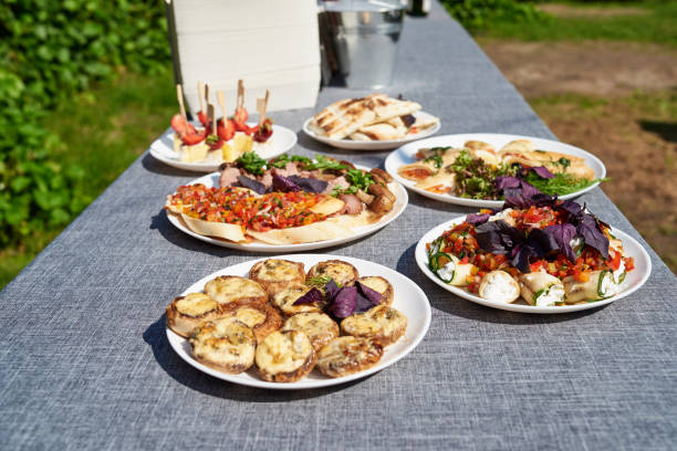 istock Plates with snacks on servered buffet table at wedding reception outdoors, copy space. Grilled mushrooms with cheese. Sandwiches, appetizer bruschetta, antipast, crostini, tapas 1341898184