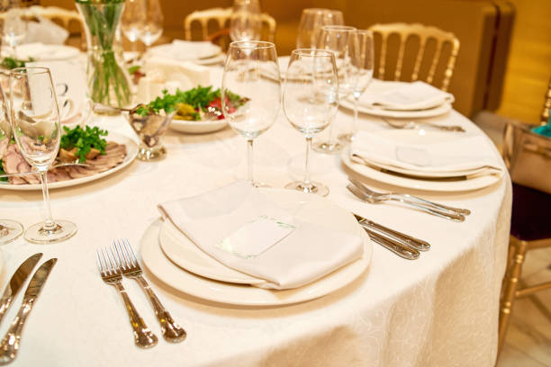 istock Table setting with blank guest card on empty white plate and cutlery on table, copy space. Menu mockup, place setting at wedding reception. Table served for wedding banquet in restauran 1341898945