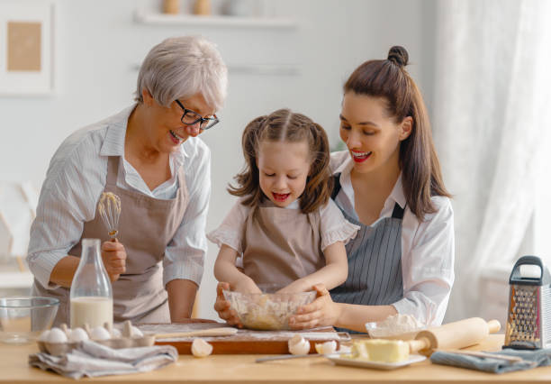 семья вместе готовит пекарню - grandmother domestic life cooking domestic kitchen стоковые фото и изображения