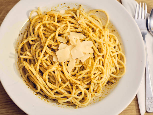 istock Spaghetti with basil pesto and cheese on white plate 1341901823