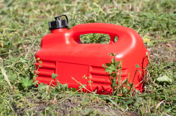 una bombola di gas di plastica rossa tra l'erba verde - gas can stranded gasoline car foto e immagini stock