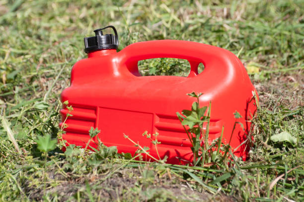 a red plastic gas canister among the green grass - gas can stranded gasoline car imagens e fotografias de stock