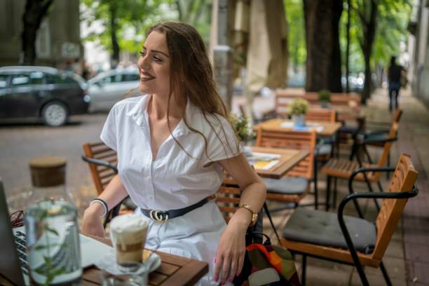 istock Businesswoman using laptop while enjoying work at cafe table with cup of coffee 1341904464