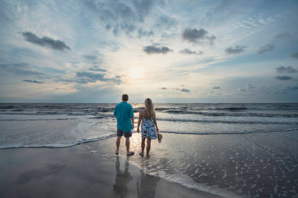 istock Couple standing on the beautiful beach at sunrise. 1341907664
