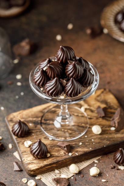 istock Chocolate candies on brown background. Background with chocolate. The chunks of broken chocolate. Chocolate with hazelnut 1341907883