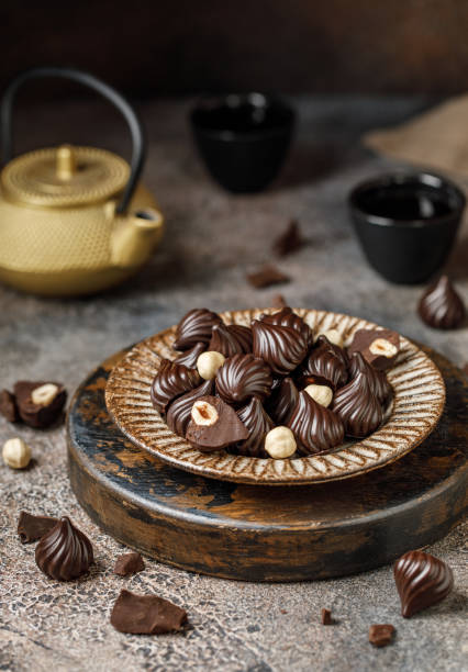 istock Chocolate candies on brown background. Background with chocolate. The chunks of broken chocolate. Chocolate with hazelnut 1341908053