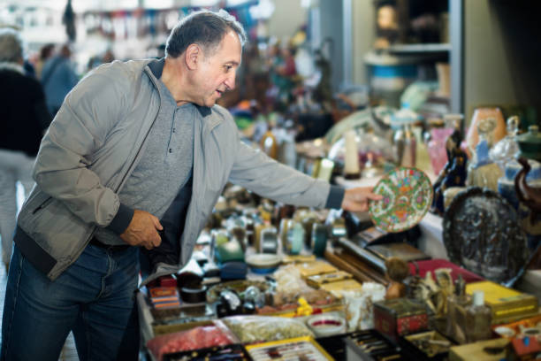 istock Senior man choosing vintage handicrafts at flea market 1341909621
