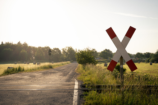 Railroad crossing in the countryside in the morning at sunrise