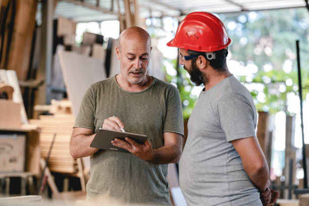 istock Middle Aged Architect Describing His Project To The Carpenter In The Carpentry Workshop 1341911382