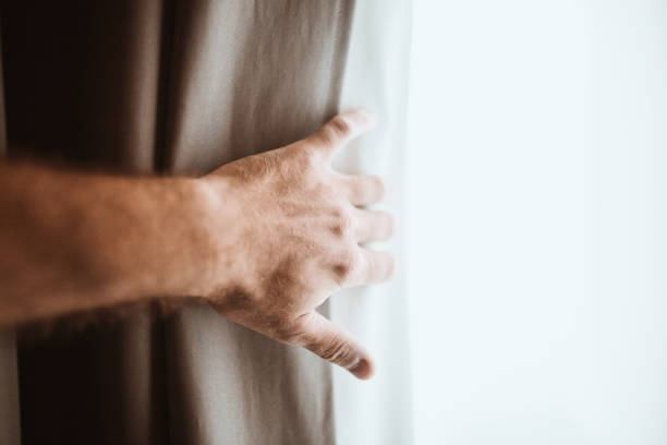 istock A new day through an open window - a male hand opens a thick curtain 1341911502