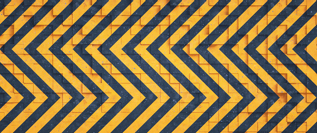 Rough industrial tiled surface with a zigzag pattern in black and orange colored stripes. Wide horizontal composition.