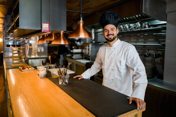 istock Happy chef working at a restaurant behind the bar counter 1341912054