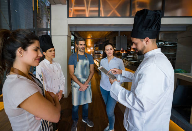 istock Chef talking to a group of workers at a restaurant 1341912058